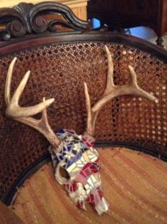 the head of a deer with antlers on it's back rests on a bed