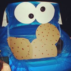 an inflatable cookie monster sitting on top of a blue chair