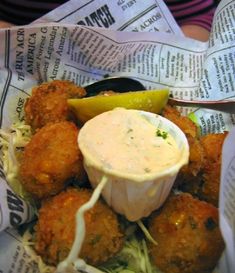 a basket filled with fried food and dipping sauce