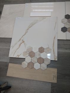 several different types of marbles and tiles laid out on top of wood flooring