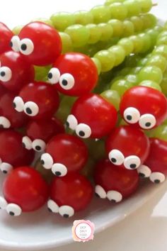 a white plate topped with green beans and red peppers covered in googly eyeballs