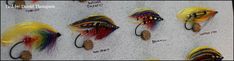 several different types of fishing lures hanging on a wall