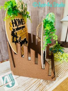 two surfboards with plants growing out of them on top of a wooden table next to a lamp