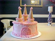 a pink and white cake sitting on top of a table