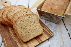 a loaf of bread sitting on top of a wooden cutting board next to a loaf of bread