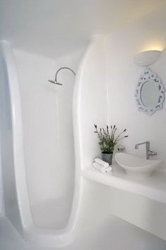 a white bathroom with a sink, mirror and bathtub in the corner is shown