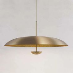 a large brass pendant light hanging from the ceiling