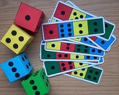 several colorful dices sitting next to each other on top of a wooden table with black dots