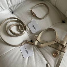 three different types of purses on a white bed with tags attached to the straps