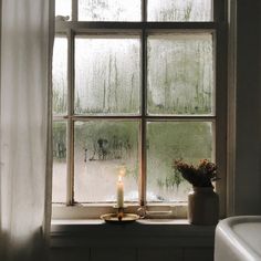 a candle is lit in front of a window