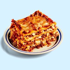 a white plate topped with lasagna covered in sauce and cheese on top of it