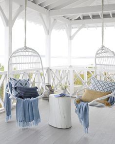 a white porch with hanging chairs and pillows