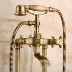 an antique brass faucet with two spray heads and hoses attached to it