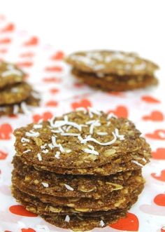 several cookies with white sprinkles on top are stacked on a red and white tablecloth