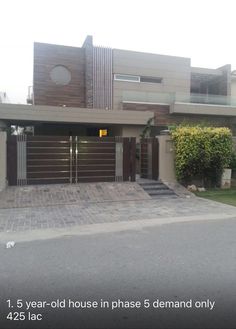 a house that is in the middle of a driveway with an attached garage and gate