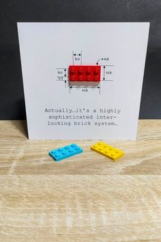 two legos are sitting on a table next to a card that says actually it's a highly applicated inner looking block system