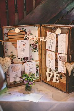 an open wooden box sitting on top of a table filled with cards and paper decorations