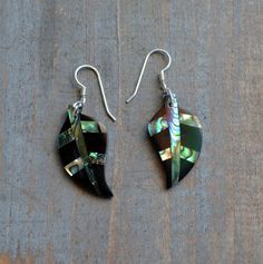 These beautiful earrings feature a cute carved Abalone shell Leaf set with black resin. . The iridescence of the Abalone shell is really amazing. Depending on the light source they will radiate colors varying from greens and pinks to purples and blues. The shells are then polished to a high gloss to reveal the beauty of their natural pattern. The perfect way to complete your beach outfit and everyday wear. DETAILS - Shell types : Abalone, Paua Shell - Material: Sterling Silver Ear Wire and Jump Gift Shell-shaped Mother Of Pearl Earrings, Black Inlay Jewelry As A Gift, Black Jewelry With Inlay For Gift, Abalone Shell Earrings For Pierced Ears As A Gift, Gift Abalone Shell Earrings, Gift Abalone Shell Earrings For Pierced Ears, Multicolor Shell-shaped Jewelry Gift, Multicolor Shell-shaped Jewelry For Gifts, Handmade Black Shell-shaped Jewelry