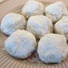 powdered sugar cookies are on a plate with red and white striped paper around it