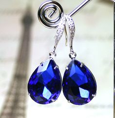 "Old Hollywood Glamor. These gorgeous earrings are made with vintage 18mm pear-shaped jewels in Sapphire Blue. The crystals have loads of facets and are set in a silver plated setting. The royal blue earrings feature sterling silver earwires that have pave CZ crystal accents for added sparkle and style. These are the perfect accessory to add a touch of color and glamor to any ensemble. Earring Length: 1 1/2\" inches long Sapphire is the birthstone for September." Royal Blue Earrings, Jeweled Earrings, Vintage Jewels, Blue Earrings, Something Blue, Gorgeous Earrings, Royal Blue, Old Hollywood, Blue Sapphire