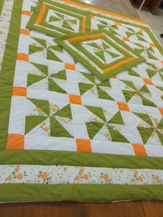 a green and white quilt on the floor