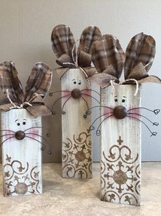 three wooden cat decorations sitting on top of a counter next to each other with bows