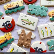 decorated cookies with fishing related items displayed on wooden table next to text that reads sweet sixteen