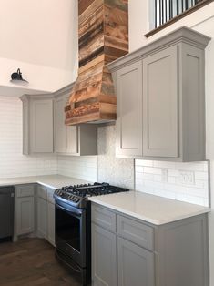 a stove top oven sitting inside of a kitchen next to a wooden block hanging from the ceiling