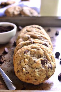 three chocolate chip cookies sitting on top of a cookie sheet