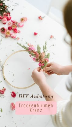 a woman is working with flowers on a white table and the words diy anleihung trockenblumen kanz