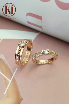 two gold wedding rings with diamonds on the top and bottom, sitting next to each other