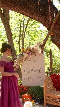 a woman in a purple dress standing next to a sign that says, we are engaged to meet you