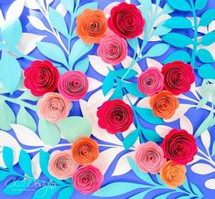 colorful paper flowers are arranged on blue and white leaves, with one red flower in the center