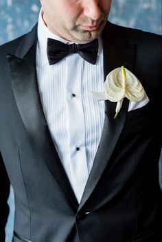 a man in a tuxedo with a flower on it's lapel