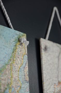 two maps hanging on the wall with rope