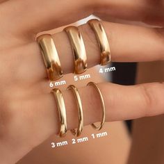 three different sizes of gold rings on someone's finger with measurements for each ring