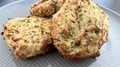 three biscuits on a white plate sitting on a table