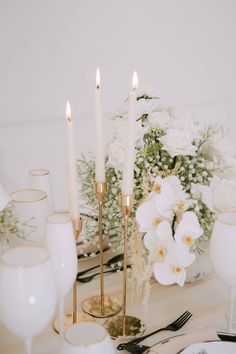 the table is set with white flowers and candles