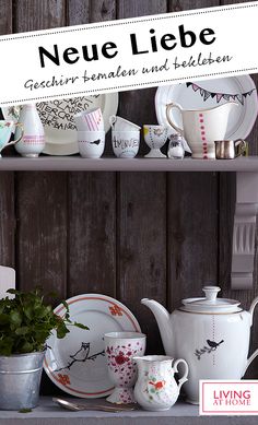 a shelf with dishes and cups on it in front of a wooden wall that says neue liebe