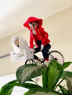 a figurine is riding a bike with a baby in a carriage on it