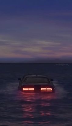 a car that is sitting in the water with its headlight turned on at night