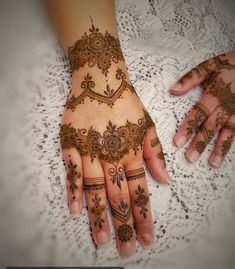 two hands with henna designs on them