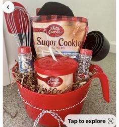 a red bucket filled with cookies and other items on top of a carpeted floor