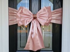 a pink bow is hanging on the front door