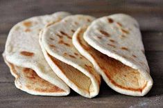 four tortillas sitting on top of a wooden table