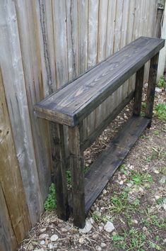 a wooden bench sitting next to a fence