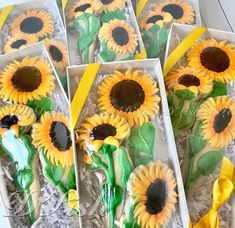 sunflowers are decorated with green leaves and yellow ribbons on display in white boxes