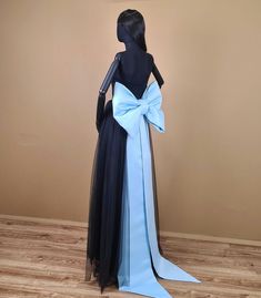 a mannequin wearing a blue and black dress with a large bow on it