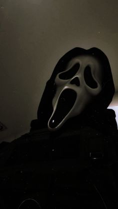 a person wearing a black hooded jacket with a white mask on their face and mouth