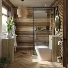 a modern bathroom with wood paneling and white fixtures, along with a plant in the corner